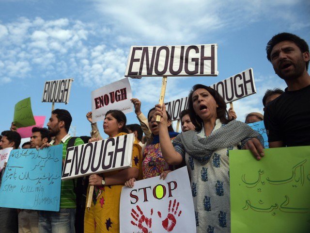 Pakistani civil society activists shout slogans during a protest against the killing of the Shiite Ismaili minority, by gunmen i