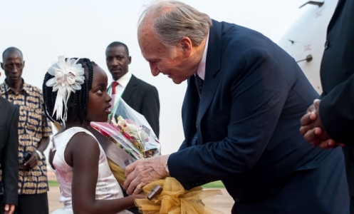 A six-year-old girl presents flowers to Mawlana Hazar Imam as he steps off the plane at Entebbe. AKDN / Will Boase
