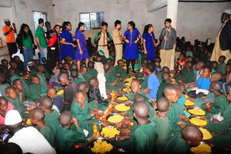 Charity. Volunteers from the Shia Ismaili National Council for Uganda distribute food to children at Kasangati Orphans Fund Soci